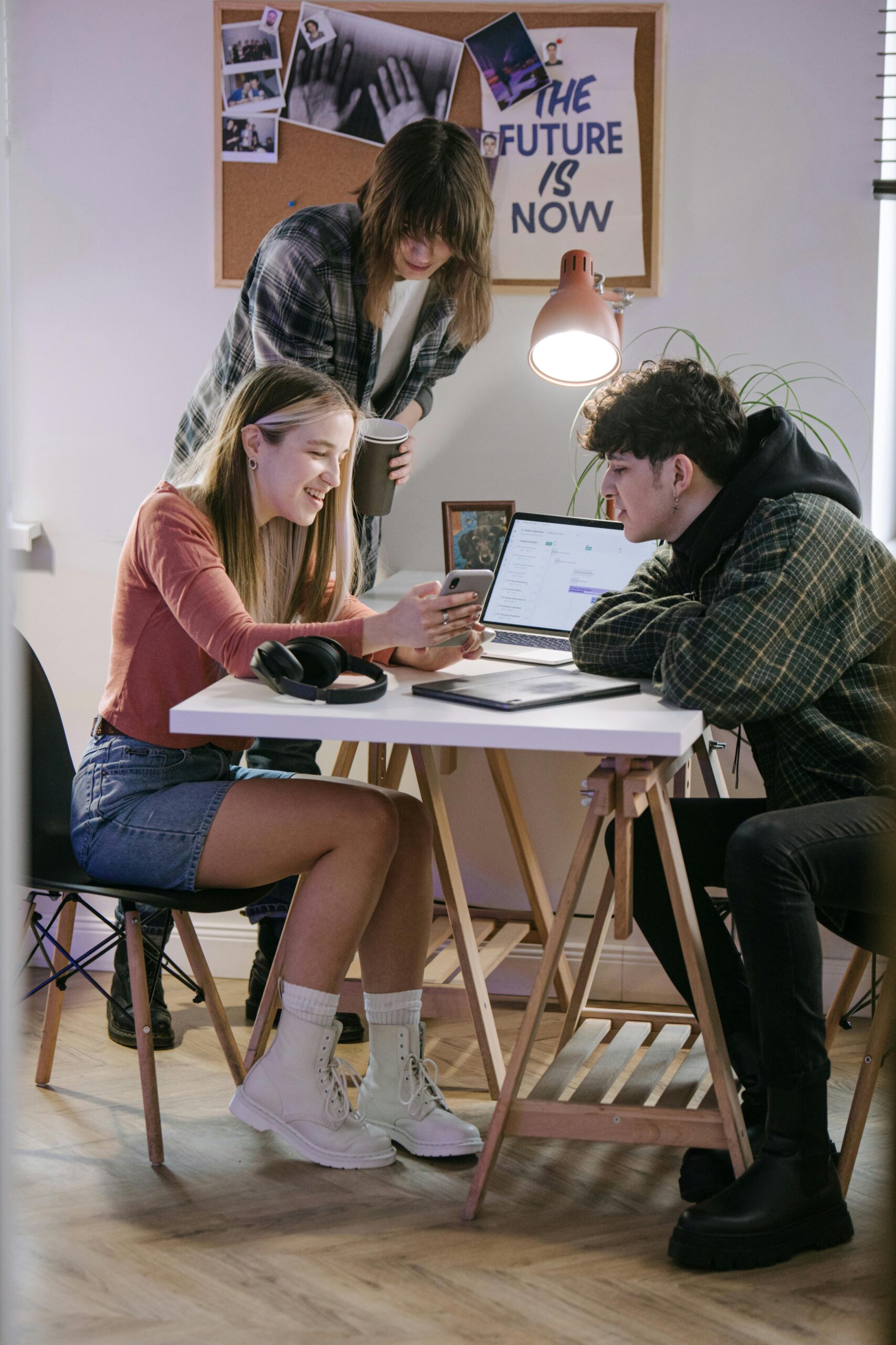 A group of young professionals working together in a modern coworking space, using technology and creativity.